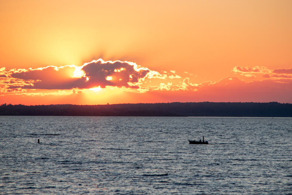 Photograph of boat, calm, cloud.