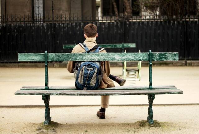 Photograph of alone, bag, bench.