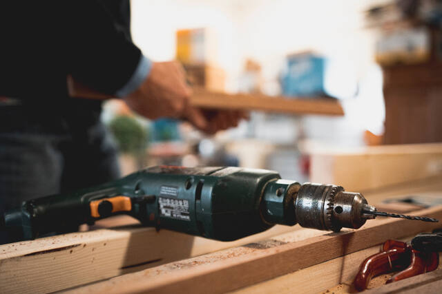 Photograph of carpenter, craftsman, drill.