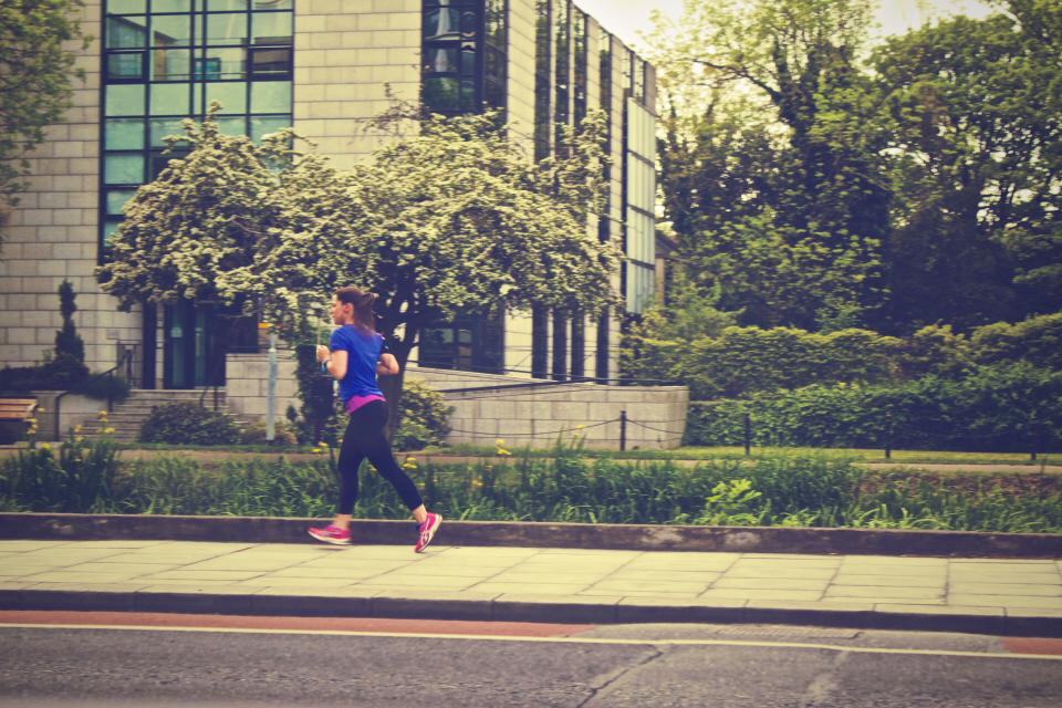 Photograph of athlete, building, city.