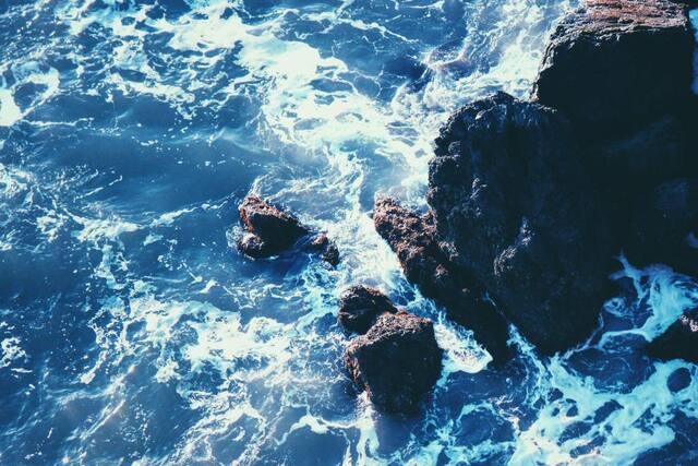 Photograph of beach, ocean, rocks.