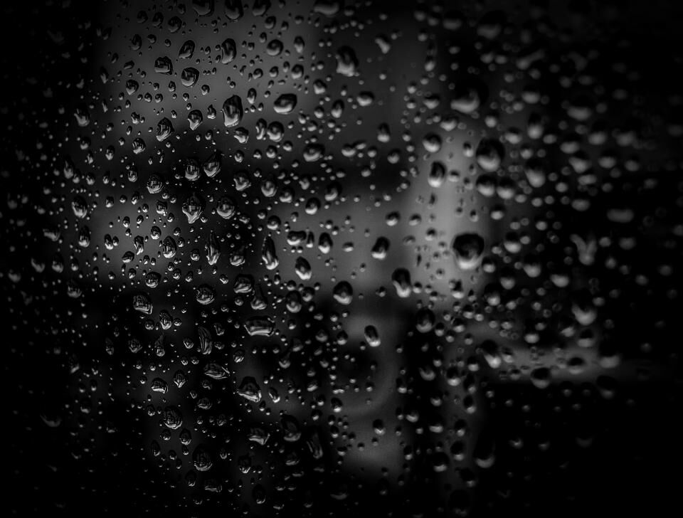 Raindrops on dark glass.