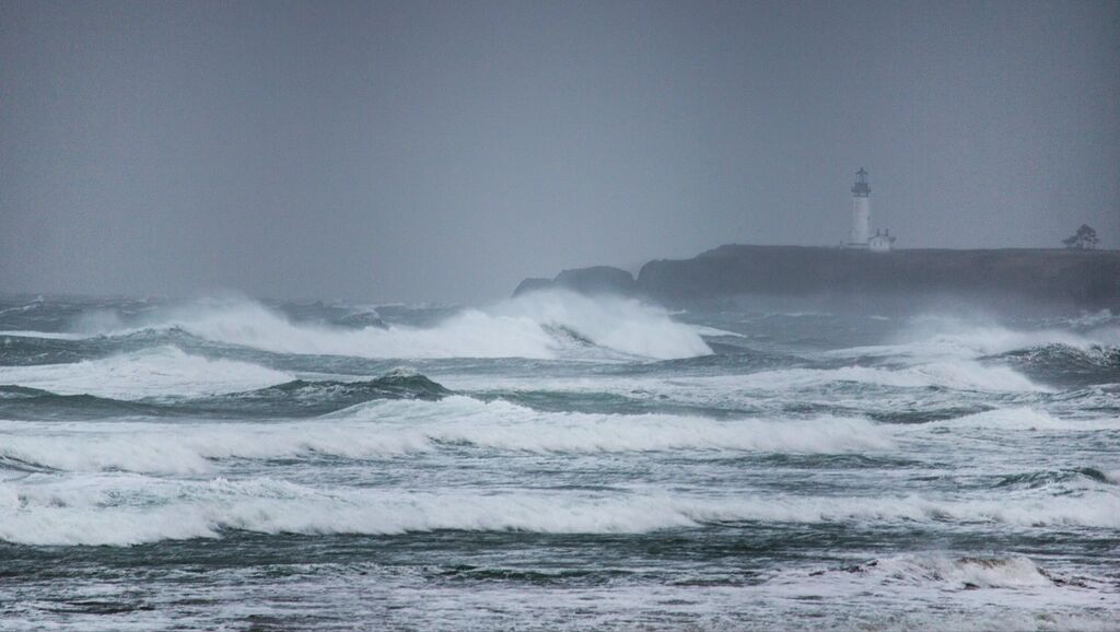 A lighthouse on a headland in a winter storm.