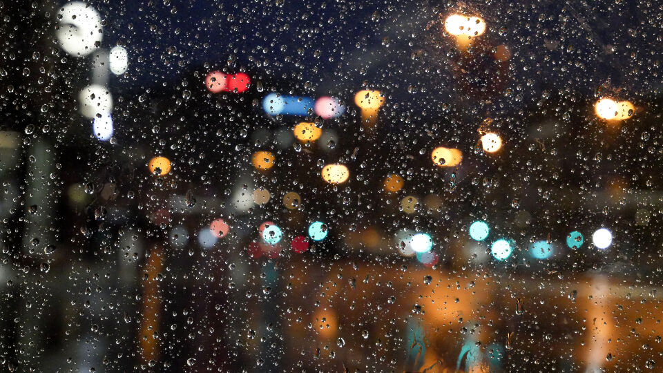 City lights blurred through a rain covered window.